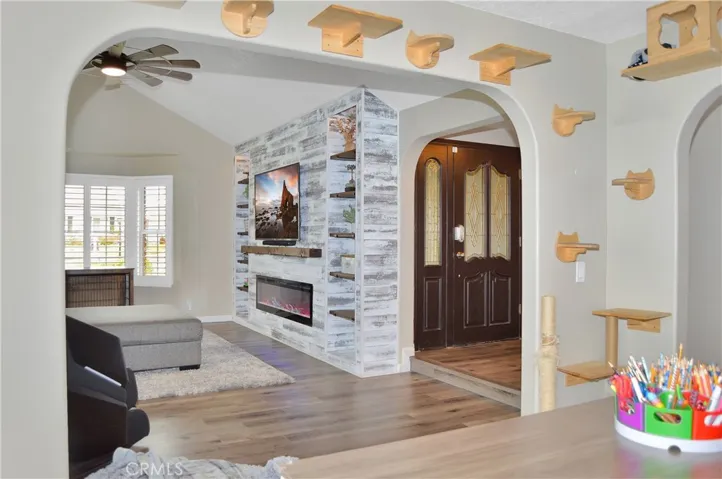 The dining room (used as an office/hobby space now) features arched entries from the living room and kitchen, more fabulous flooring, and a sliding door to the backyard. (TV image added virtually)