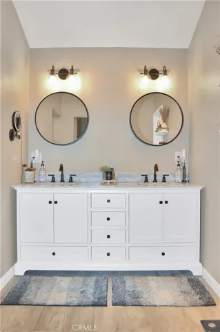 The amazing main suite bath features a furniture-style dual sink vanity at the entry with an absolutely amazing spa-like shower and bath wet room to the left and a walk-in closet to the right.