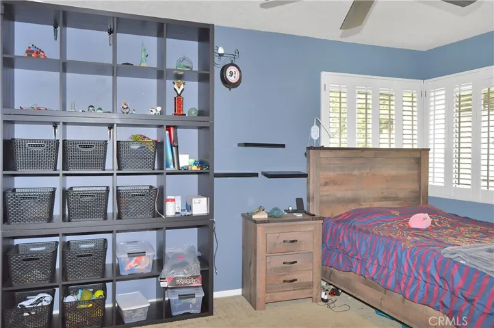 The 2nd bedroom is across the hall from the main suite and offers barn door access to the "Jack and Jill" bath, louvered shutters, and a ceiling fan