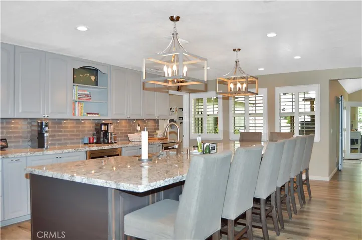 Wow! This fantastic kitchen remodel boasts seating for eight at the "chef's table" style bar, stainless steel appliances (with TWO dishwashers, a professional quality range with pot filler, refrigerator, microwave, and beverage fridge), gorgeous granite countertops, full tile backsplash, two-tone cabinetry (yes, there are cabinets on BOTH sides of the bar), fabulous lighting, pop-up outlets with phone chargers, and a walk-in pantry!
