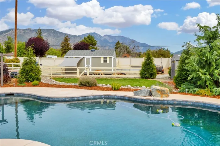 The sparkling pool and spa were built in 2021 and include a dark bottom for better heat retention (but they have heaters, too), a water slide, a jumping rock, a reef area with umbrella, a lighted gazebo with a fireplace included (fire added virtually), towel rack, concrete decking for sunbathing, lawn area for relaxing, and a handy storage shed. Pool party anyone?