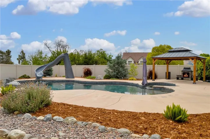 The sparkling pool and spa were built in 2021 and include a dark bottom for better heat retention (but they have heaters, too), a water slide, a jumping rock, a reef area with umbrella, a lighted gazebo with a fireplace included (fire added virtually), towel rack, concrete decking for sunbathing, lawn area for relaxing, and a handy storage shed. Pool party anyone?