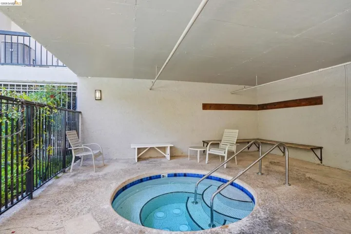 Circular spa with mosaic tile interior and stainless steel handrails
