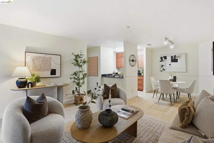 Open-concept living space featuring wood-finish flooring and light-toned walls