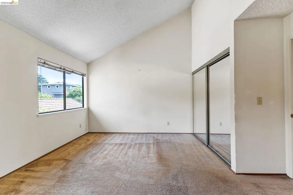 Unfurnished bedroom featuring a high textured ceiling, carpet floors, and a closet