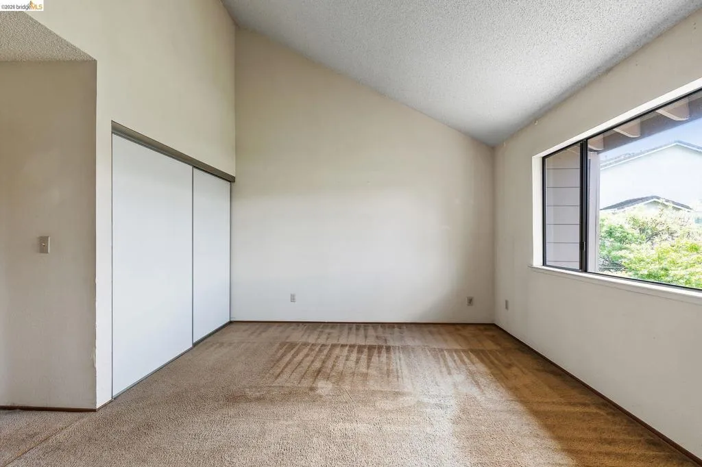 Unfurnished bedroom with light colored carpet and a closet