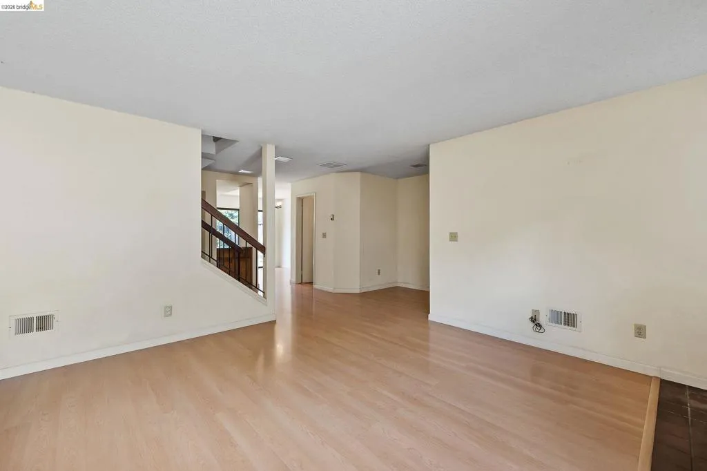 Unfurnished room with light wood finished floors and a textured ceiling