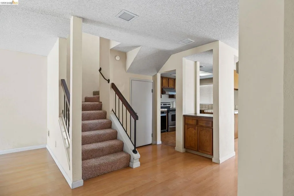 Staircase featuring wood finished floors and a textured ceiling