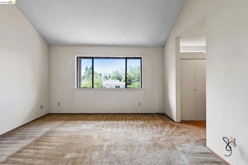 Spare room with light carpet and a textured ceiling