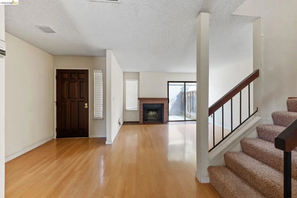 Foyer with a tile fireplace, light wood finished floors, and a textured ceiling