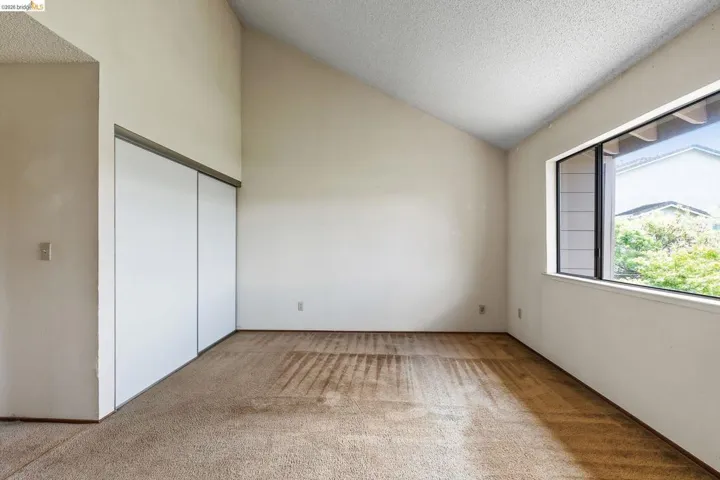 Unfurnished bedroom with light colored carpet and a closet