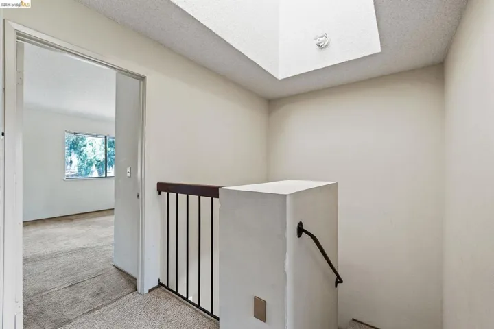 Stairway with a textured ceiling, a skylight, and carpet floors
