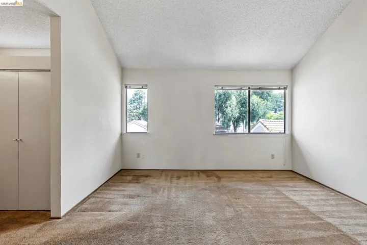Spare room featuring light carpet and a textured ceiling