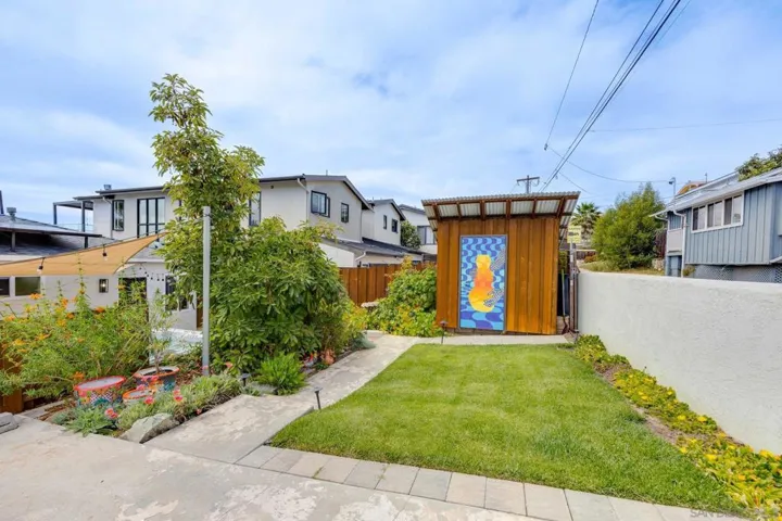 2 grassy areas and an artsy storage shed are located in the back area, with additional parking.