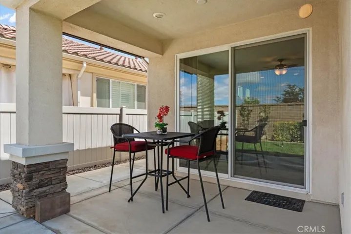 Covered patio with mature landscaping and fruit trees