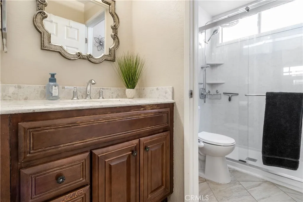 view of the single vanity, private water room and walk in shower primary bathroom and walk in secondary shower