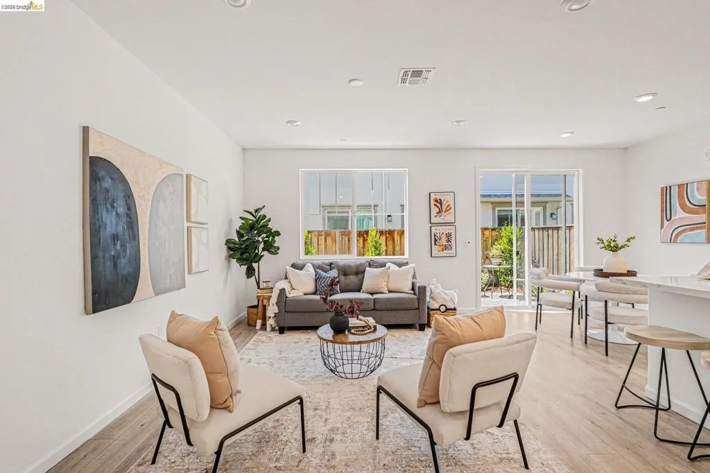 Open-concept living space featuring wood-finish flooring, recessed lighting, and white walls