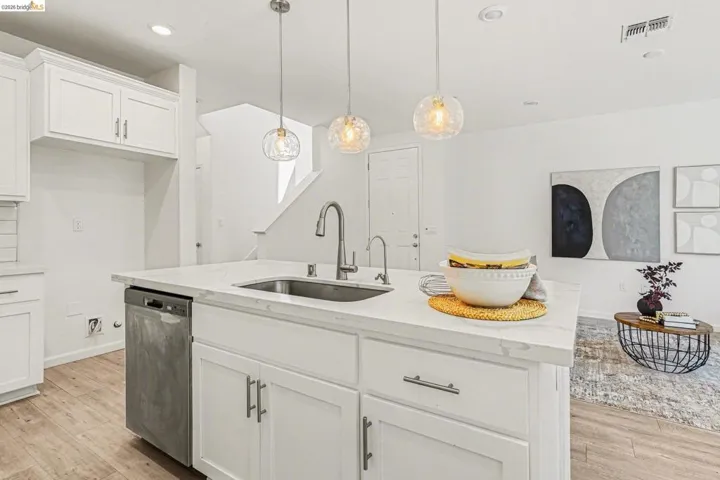 Kitchen island featuring a single-basin sink, stainless steel faucet, and white countertop