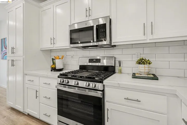 Modern kitchen featuring white shaker cabinetry with brushed nickel hardware
