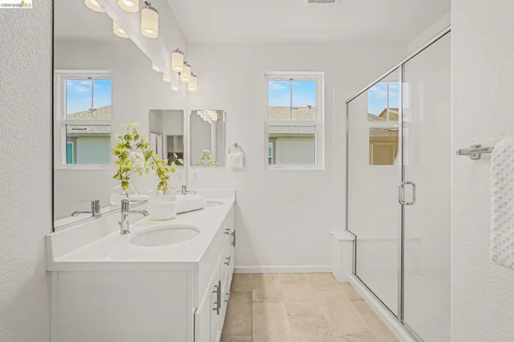 Dual vanity with integrated sinks, white countertops, and chrome fixtures