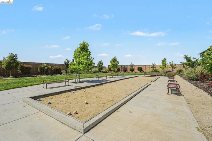 Bocce ball court featuring sand playing surfaces, concrete borders, and permanent bench seating