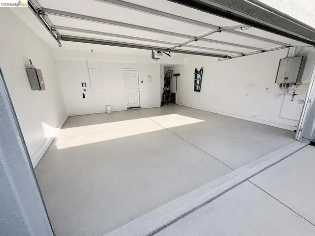 Spacious garage featuring a light gray concrete floor and white painted walls