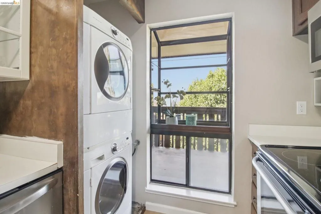 Laundry area with stacked washer and clothes dryer
