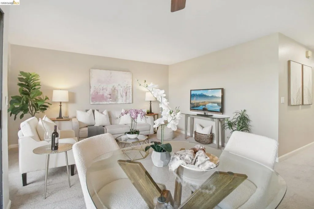 Dining space featuring light colored carpet and a ceiling fan