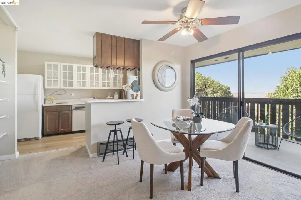 Dining space with light carpet, ceiling fan, and baseboard heating