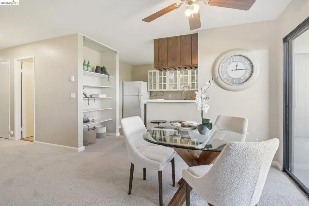 Dining area with light colored carpet and ceiling fan