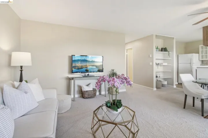 Living area featuring a ceiling fan and light carpet