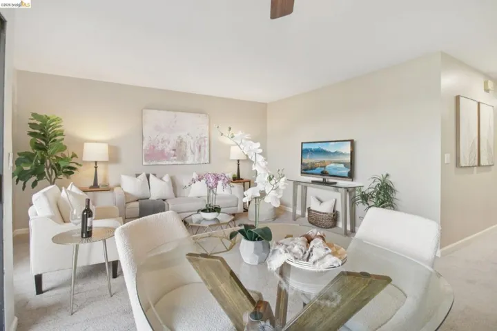 Dining space featuring light colored carpet and a ceiling fan