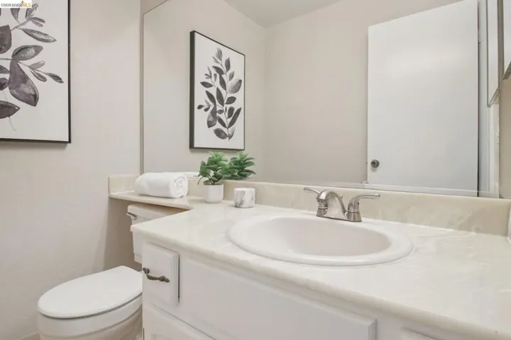 Half bathroom featuring vanity and toilet