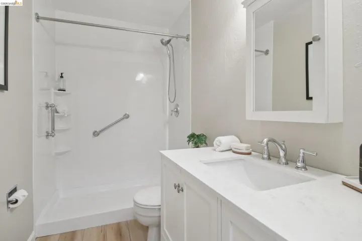Bathroom featuring vanity, a stall shower, and light wood-style floors