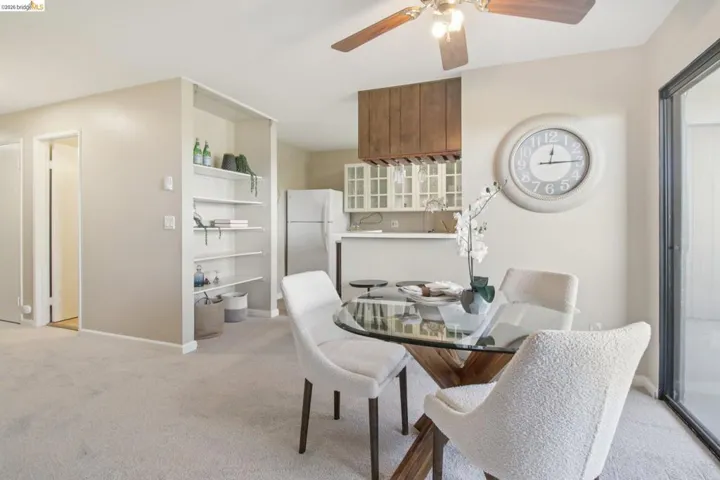 Dining area with light colored carpet and ceiling fan