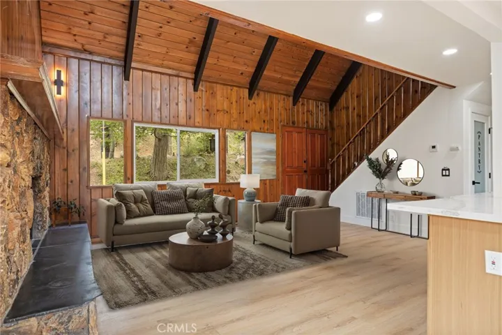 Level entry living area with modern rustic finishes and beautiful vaulted ceilings. (Virtually staged)