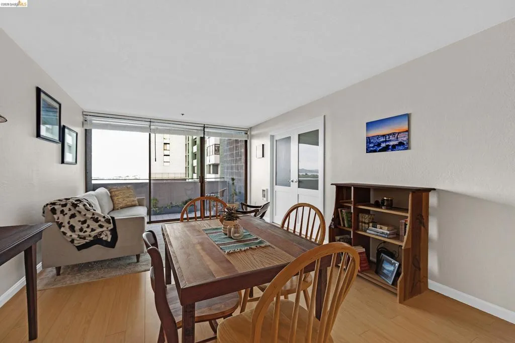 Dining area with light wood-style floors and floor to ceiling windows