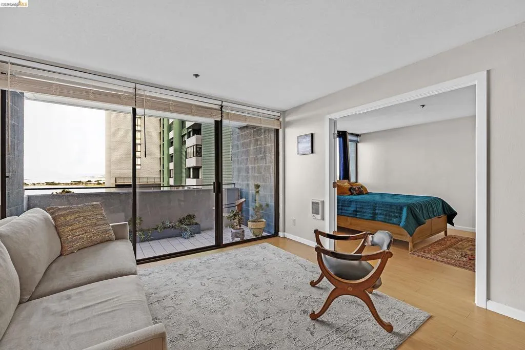 Living room with light wood-type flooring and heating unit