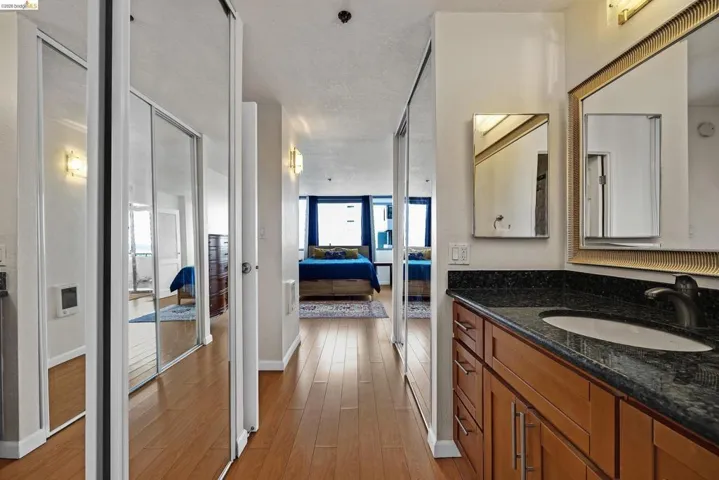 Bathroom with vanity, ensuite bathroom, light wood-style flooring, and heating unit