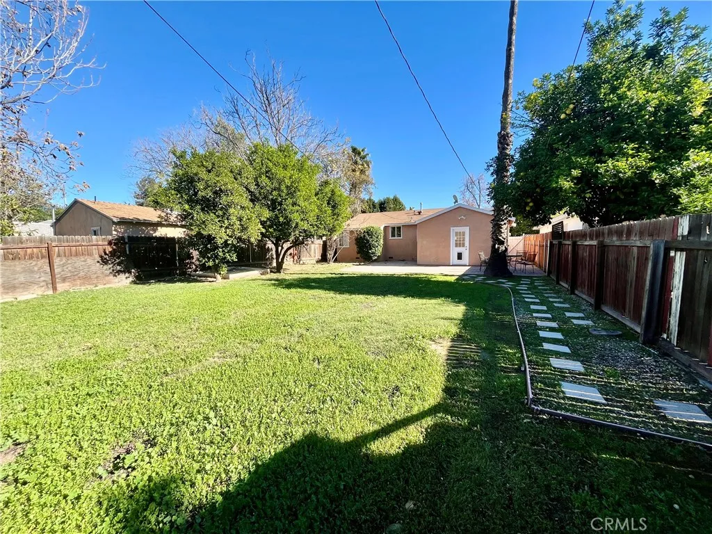 Large fenced back yard looking toward back of house
