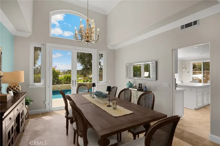 Enjoy indoor-outdoor dining with French doors that open to the sparkling pool and serene backyard views