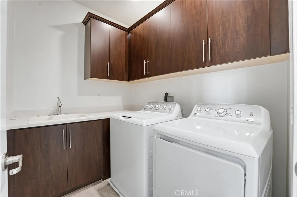 Full laundry room with sink and additional cupboards
