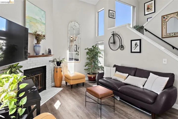 living room with wood finished floors, a high ceiling, and a fireplace
