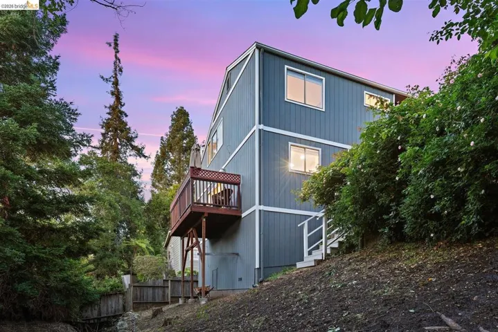 back of property at dusk with stairs and a deck