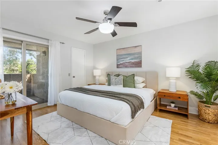 Primary Bedroom #1 with Laminate Floors, Walk-in Closet, Built-in Cabinets and updated Sliders to the Balcony
