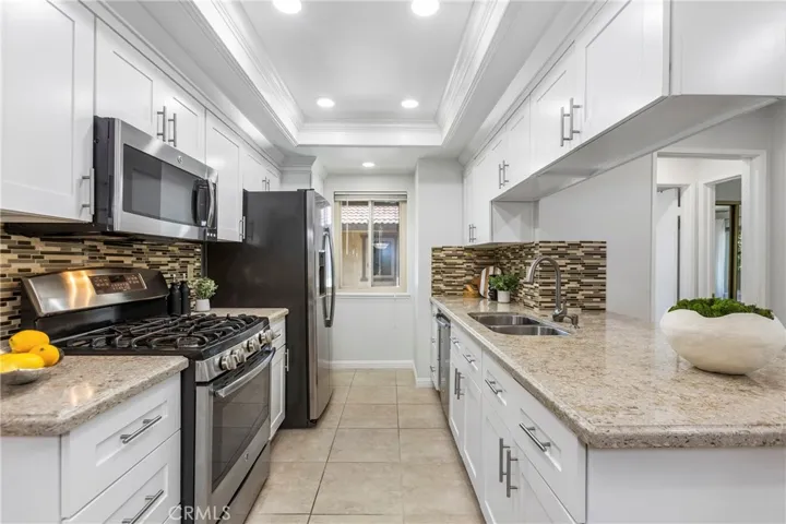 Open & Updated Kitchen - with White Shaker Cabinets, Quartz Counters, Stainless Appliances, 5 Burner Stove w/Griddle, Tray Ceilings with Recessed Lighting and Crown Molding