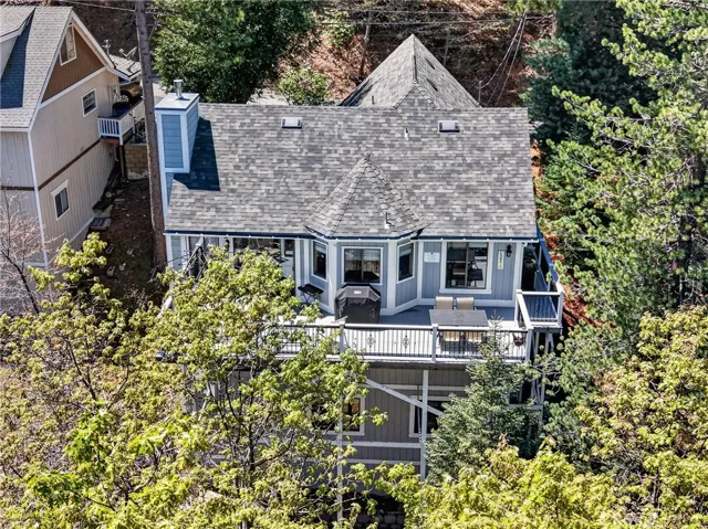 Back of home overlooks wooded area. Empty lot to the left of home