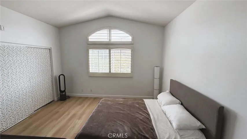 Primary bedroom with lots of natural light and mirrored closet doors behind the peel and stick wallpaper.