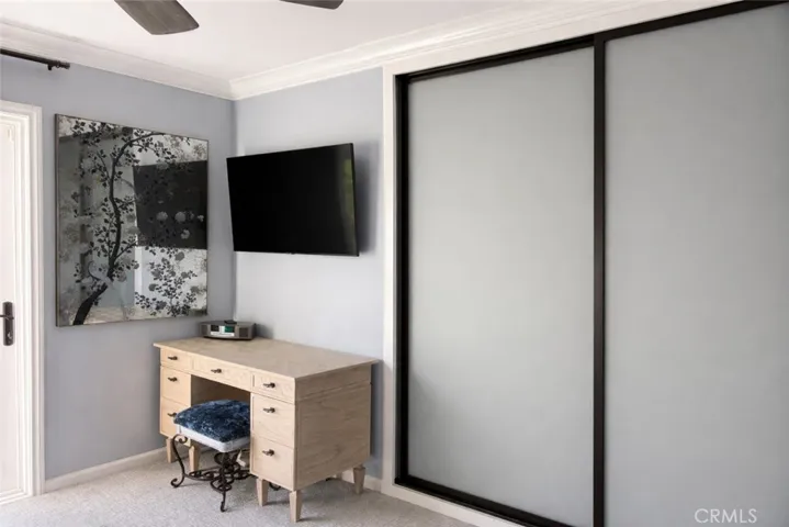 Bedroom with ceiling fan, large closet with custom organizer