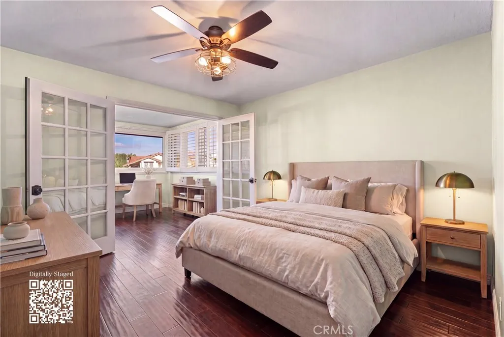Top floor bedroom with bonus office space. Ceiling fan and french doors. Virtually staged, find originals at https://bit.ly/3OvKmPn